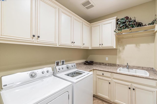 laundry room featuring cabinets, separate washer and dryer, and sink