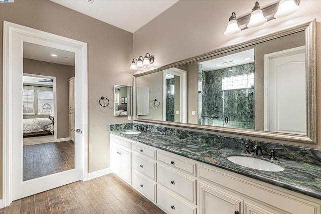 bathroom with hardwood / wood-style flooring, vanity, and walk in shower