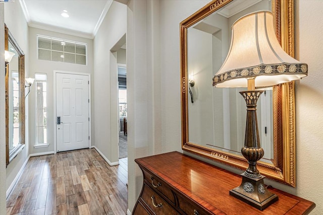 foyer entrance featuring a wealth of natural light, light hardwood / wood-style floors, and ornamental molding