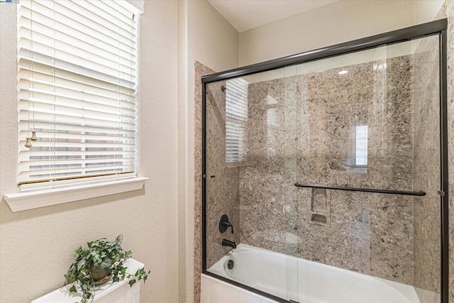 bathroom with combined bath / shower with glass door