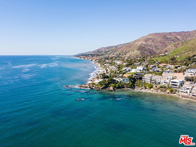 drone / aerial view featuring a water and mountain view