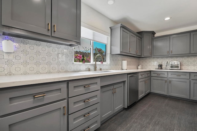 kitchen with stainless steel dishwasher, sink, gray cabinetry, and backsplash