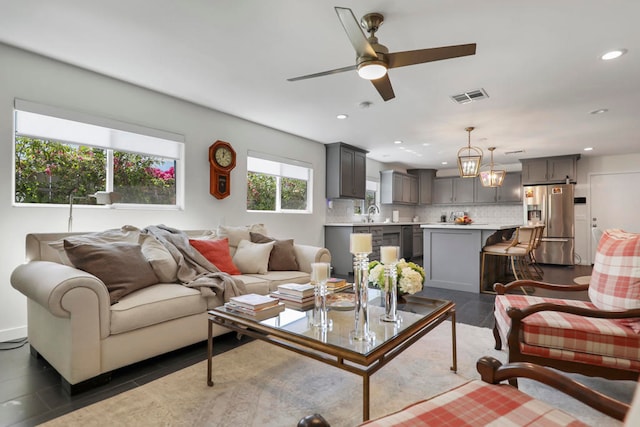 living room with ceiling fan with notable chandelier