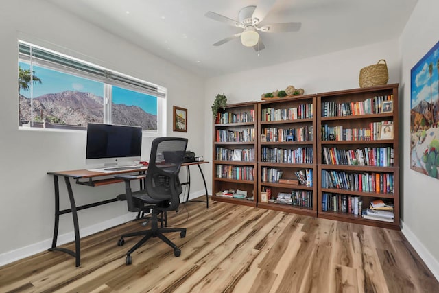 home office featuring wood-type flooring and ceiling fan