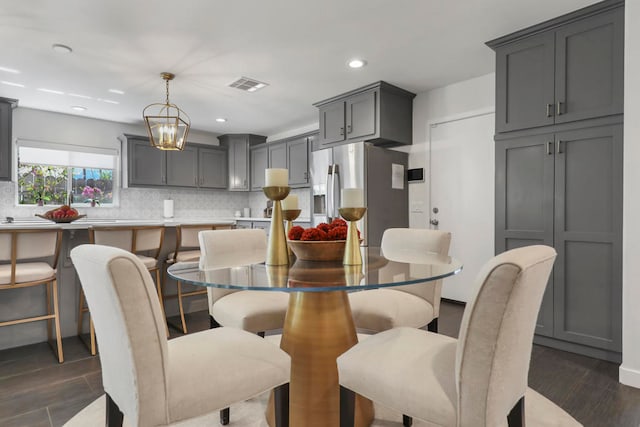 dining area with dark wood-type flooring and a chandelier