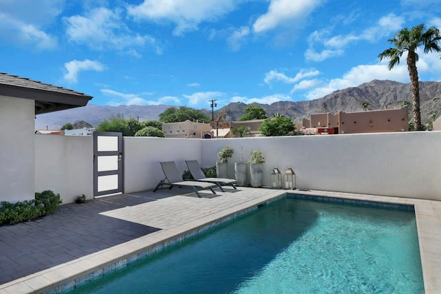 view of swimming pool featuring a patio area and a mountain view