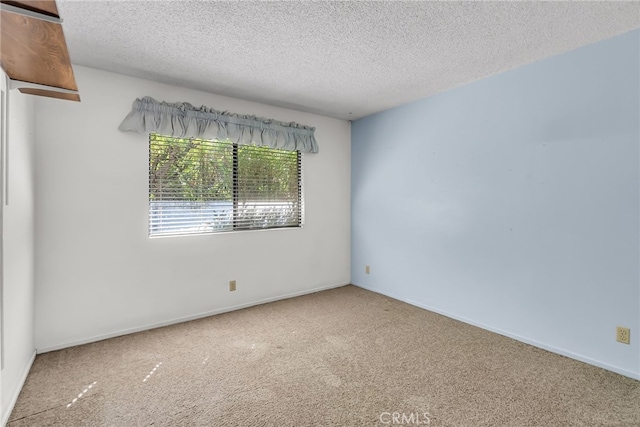 carpeted spare room with a textured ceiling