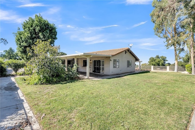 rear view of property featuring a yard and a patio area