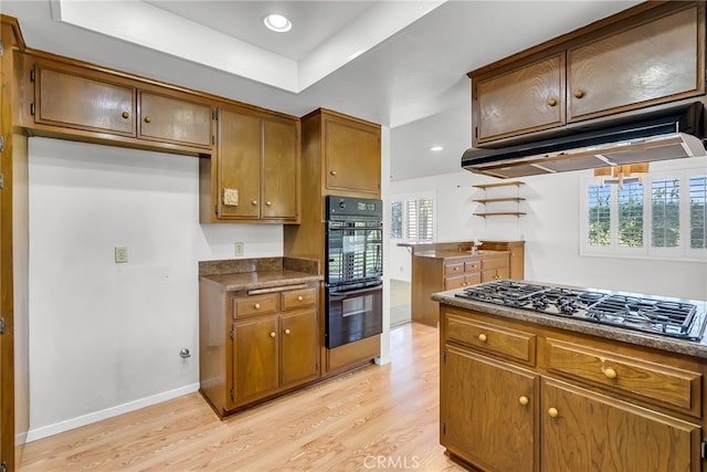 kitchen with double oven, stainless steel gas cooktop, and light wood-type flooring