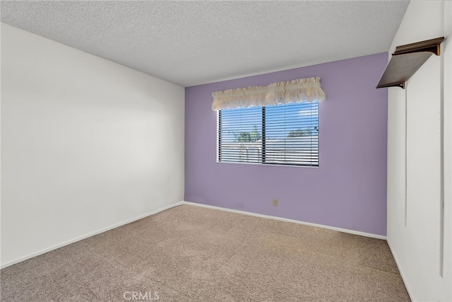 carpeted empty room with a textured ceiling