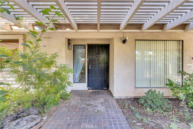 view of exterior entry featuring a pergola