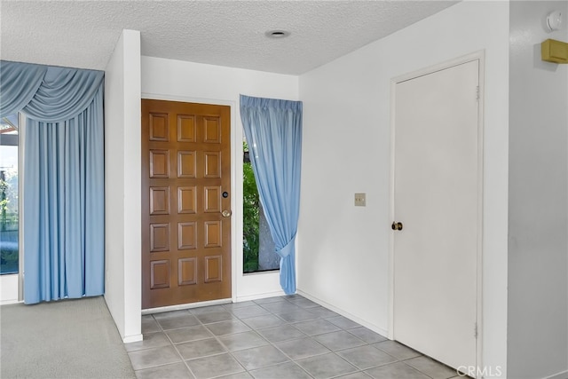 tiled foyer with a textured ceiling