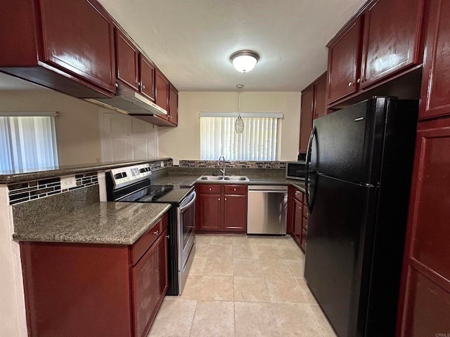 kitchen with kitchen peninsula, decorative backsplash, stainless steel appliances, sink, and decorative light fixtures