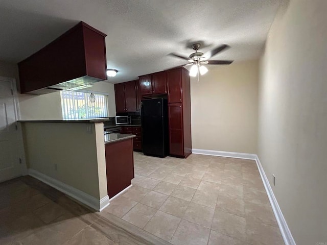 kitchen with kitchen peninsula, light tile patterned floors, ceiling fan, a textured ceiling, and black refrigerator