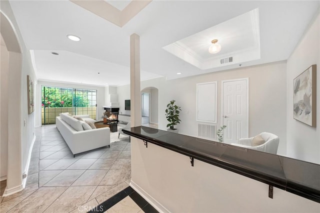 interior space with white cabinetry, light tile patterned floors, and a tray ceiling