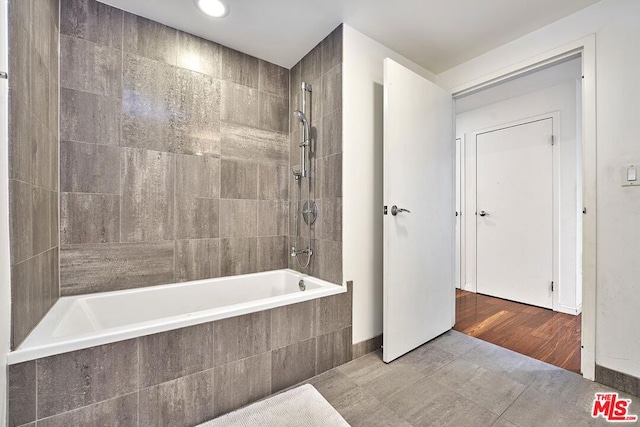 bathroom featuring wood-type flooring and tiled shower / bath combo