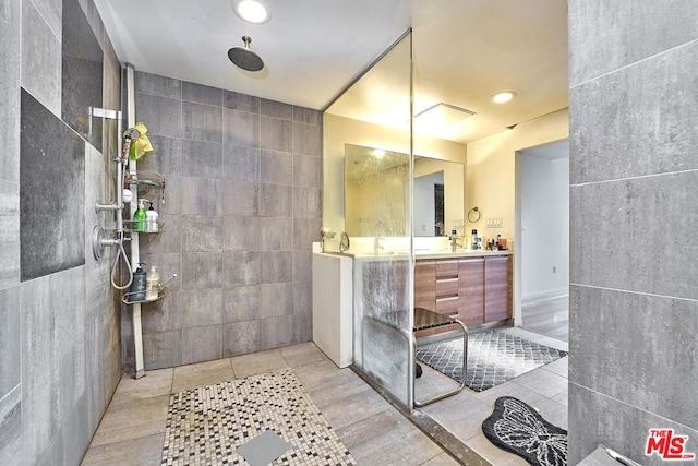 bathroom featuring tile patterned flooring, vanity, and tile walls