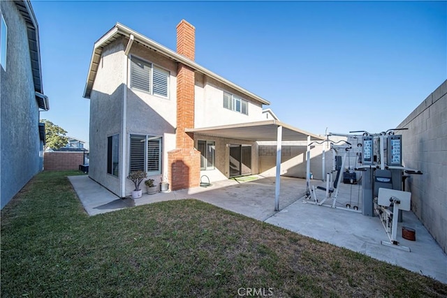 rear view of property featuring a patio area and a yard