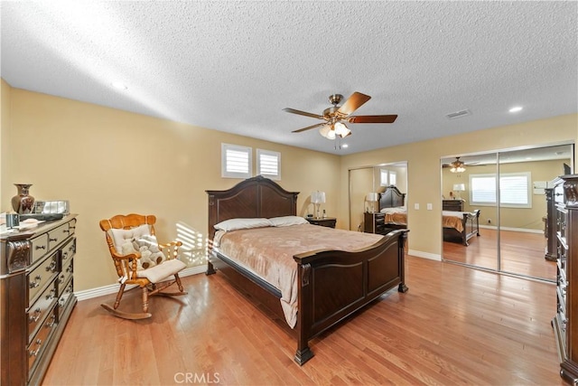 bedroom with ceiling fan, light hardwood / wood-style flooring, and multiple windows