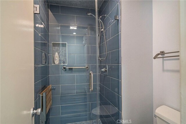 bathroom with toilet and an enclosed shower