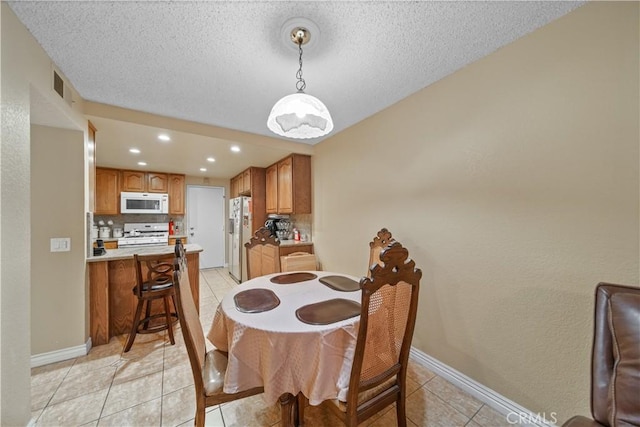 dining room with a textured ceiling and light tile patterned floors