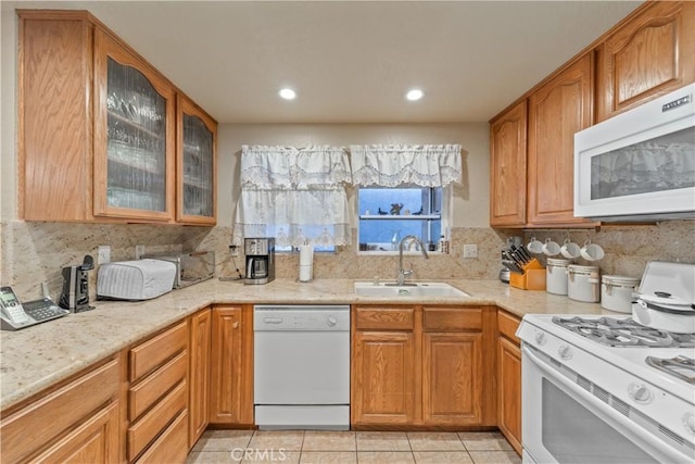 kitchen with tasteful backsplash, sink, white appliances, and light tile patterned flooring