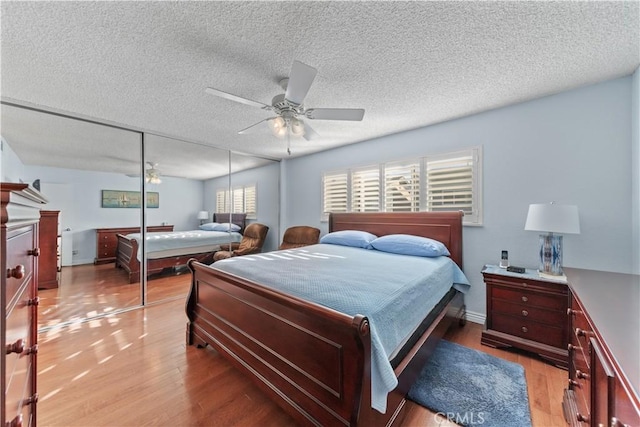 bedroom with ceiling fan, a closet, and light hardwood / wood-style floors