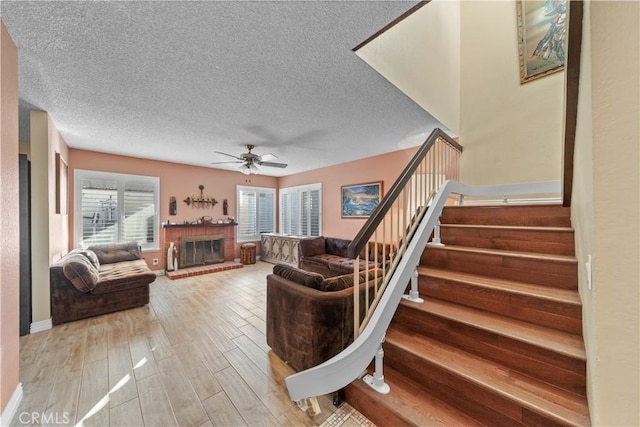 living room featuring ceiling fan and a brick fireplace