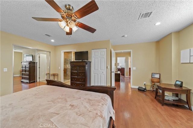 bedroom featuring ceiling fan, light hardwood / wood-style floors, a textured ceiling, and a closet