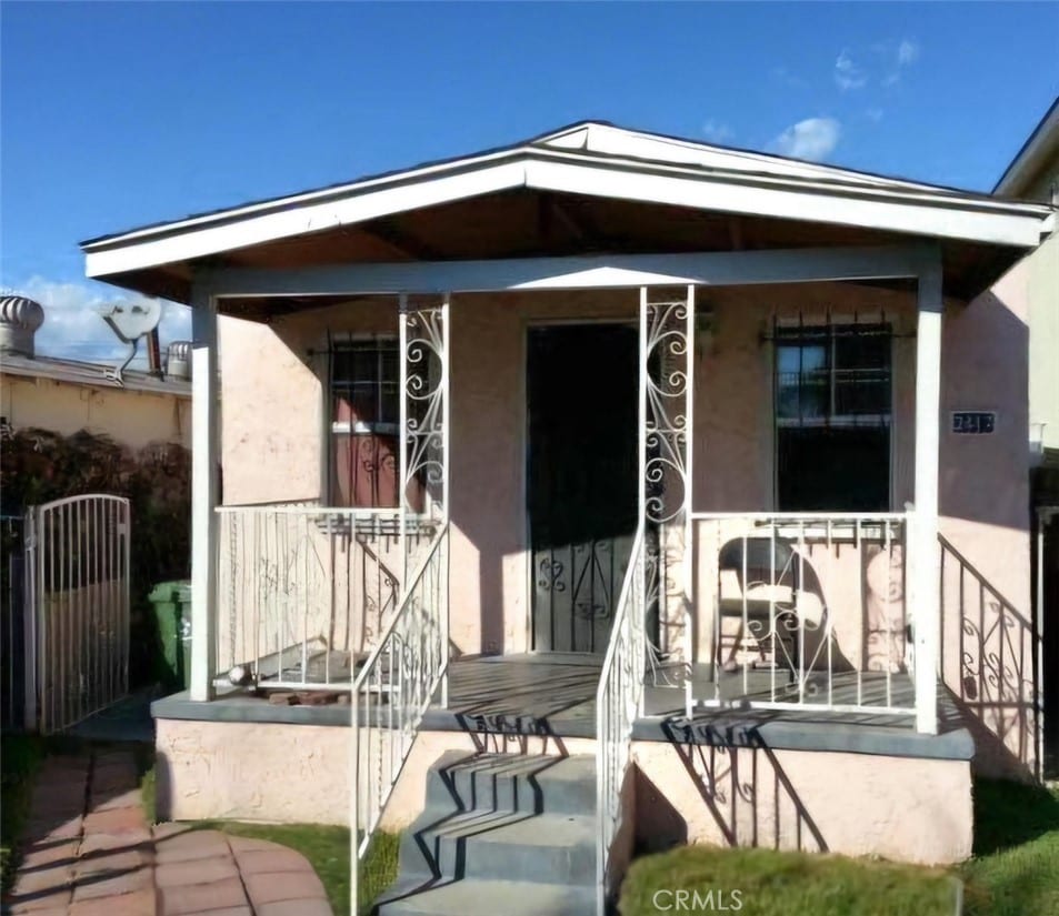 back of property featuring covered porch