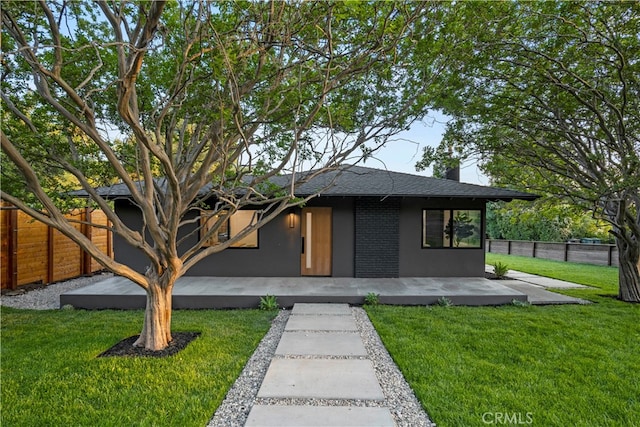 view of front of house with a patio area and a front yard