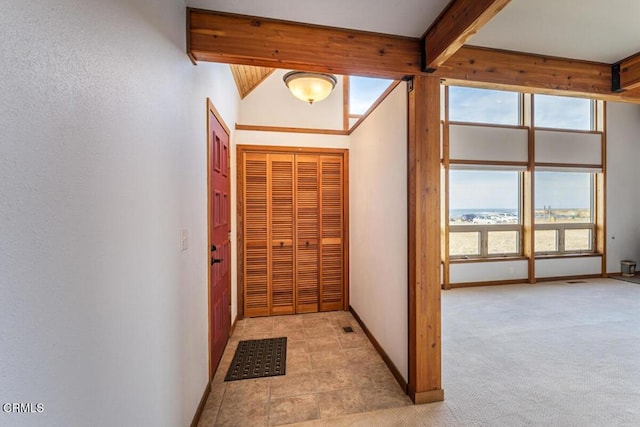 interior space featuring vaulted ceiling with beams and light carpet