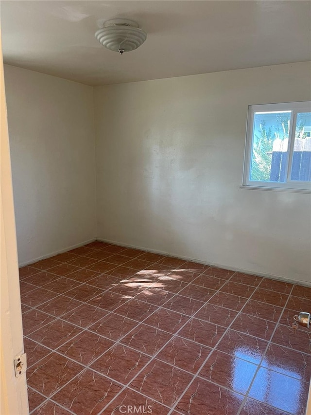 spare room featuring dark tile patterned floors