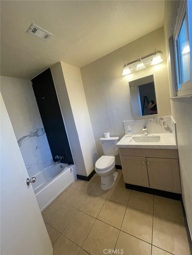 bathroom featuring vanity, tile patterned floors, toilet, and a washtub