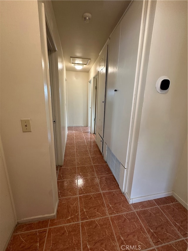 corridor featuring dark tile patterned flooring