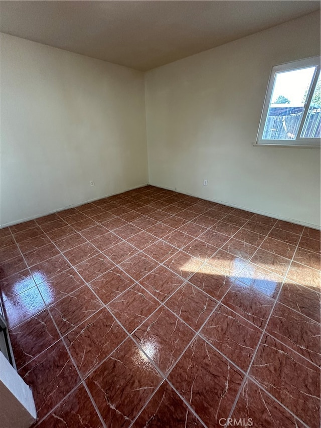 unfurnished room featuring dark tile patterned flooring