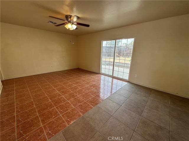 empty room with ceiling fan and tile patterned floors