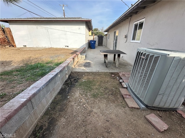 view of yard with central air condition unit and a patio