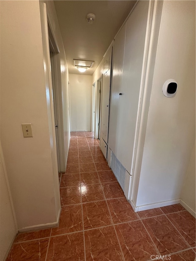 corridor with dark tile patterned flooring