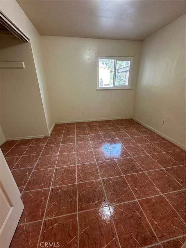 unfurnished room with dark tile patterned flooring