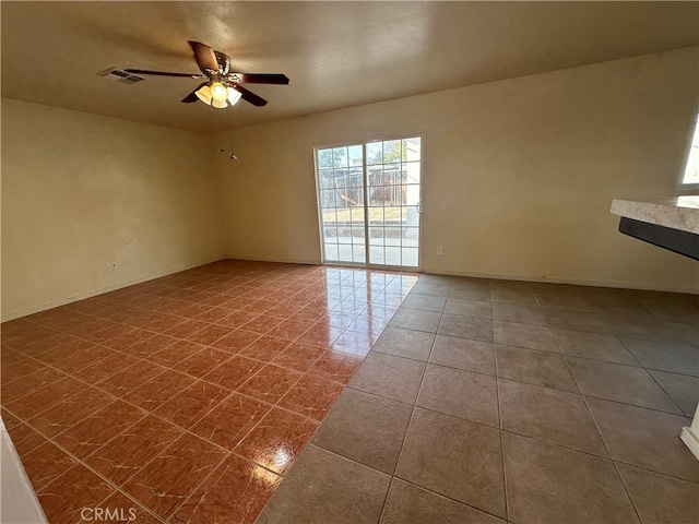 tiled empty room featuring ceiling fan