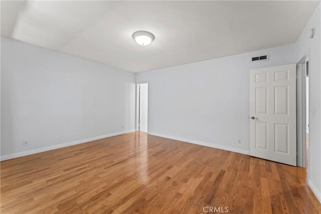 empty room with light hardwood / wood-style flooring