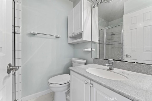 bathroom with tile patterned flooring, vanity, toilet, and walk in shower