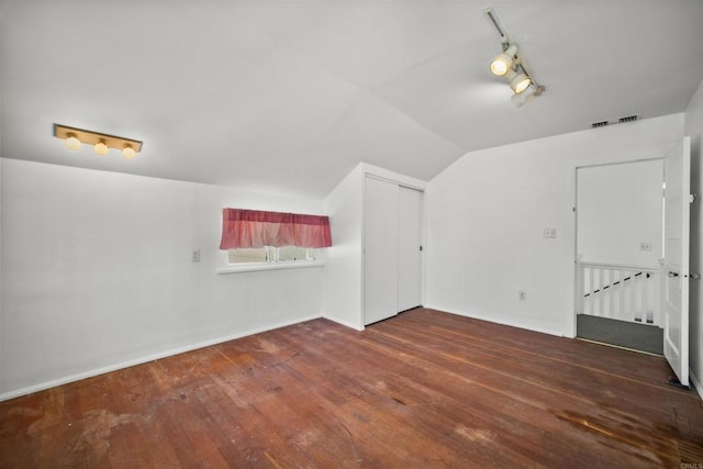 additional living space with dark hardwood / wood-style floors and vaulted ceiling