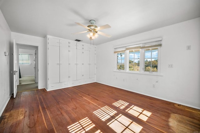 unfurnished bedroom featuring dark hardwood / wood-style flooring, a closet, and ceiling fan