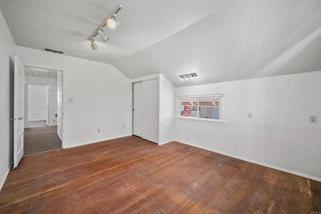 additional living space with lofted ceiling and hardwood / wood-style flooring