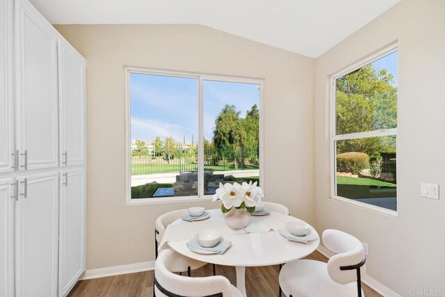 dining area featuring light hardwood / wood-style floors and lofted ceiling