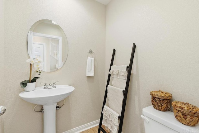 bathroom featuring hardwood / wood-style flooring and toilet