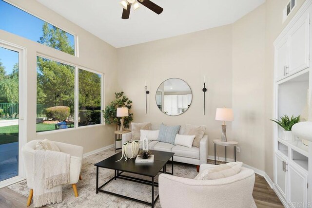 living room featuring wood-type flooring and ceiling fan