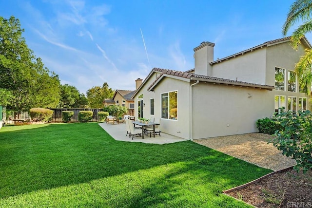 rear view of property featuring a lawn and a patio